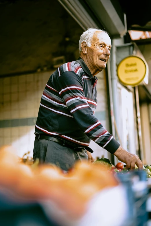 a man with white hair standing next to a pile of food