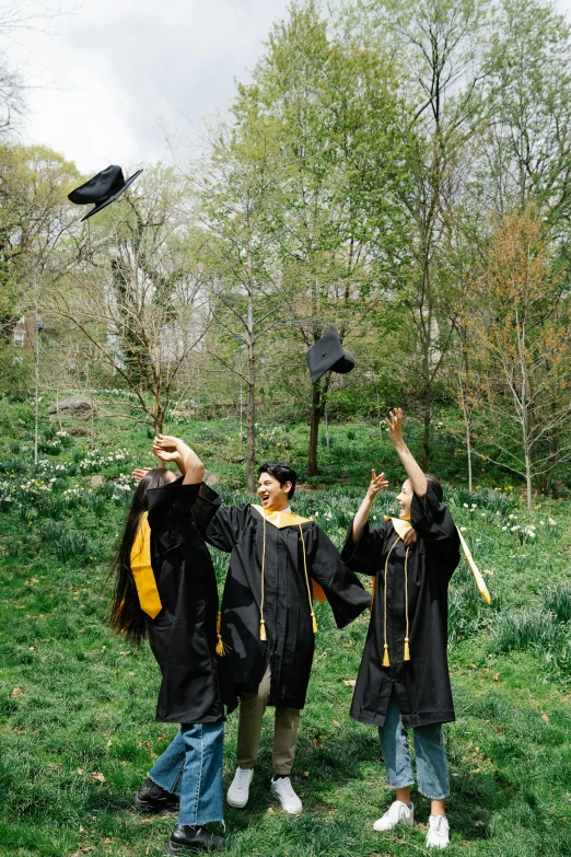 three people posing for a picture while wearing graduation robes