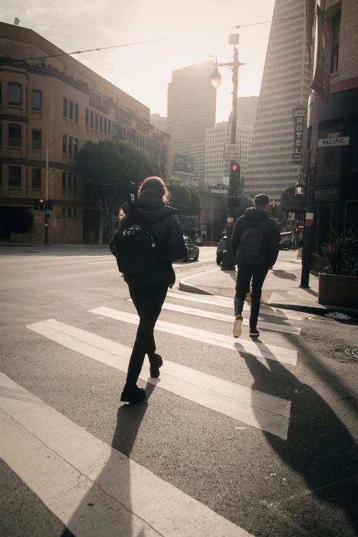 a man and woman are crossing a street