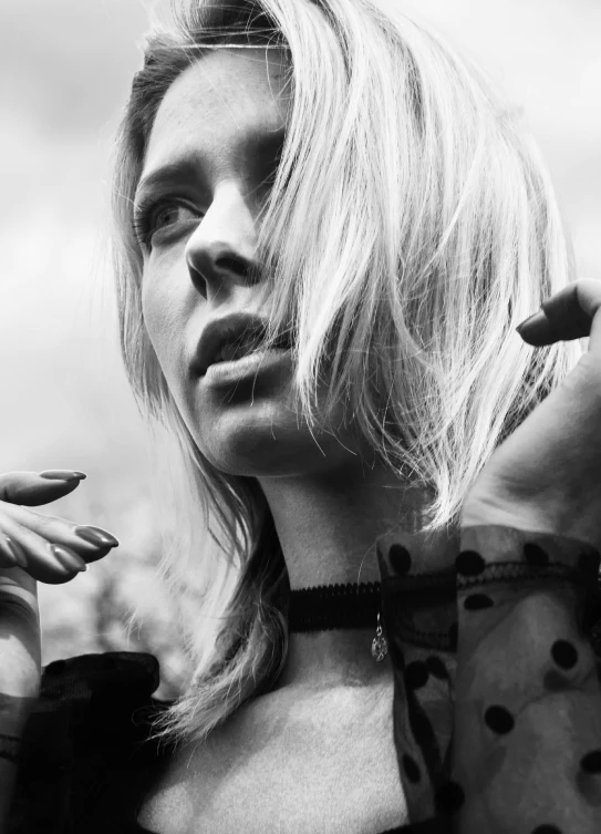 a young lady standing in front of a building smoking a cigarette