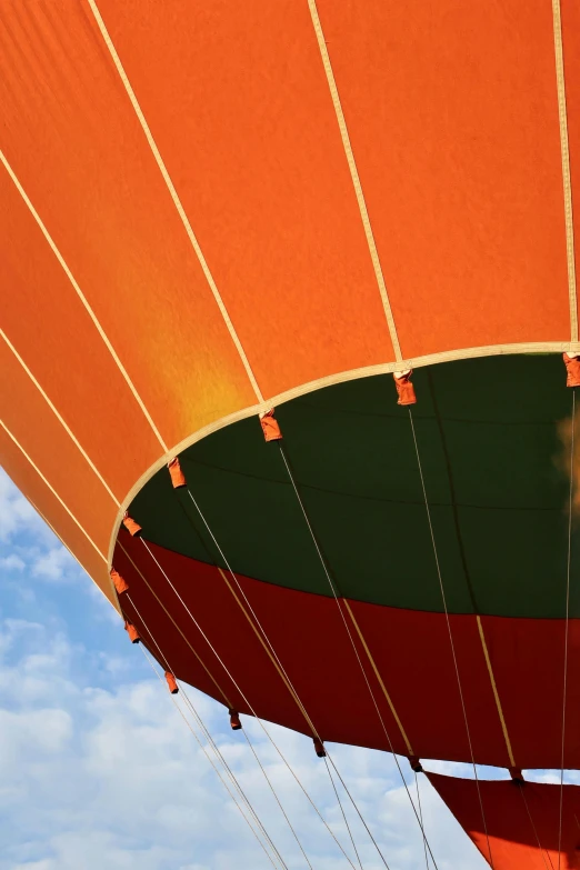 a large orange  air balloon flying through the air