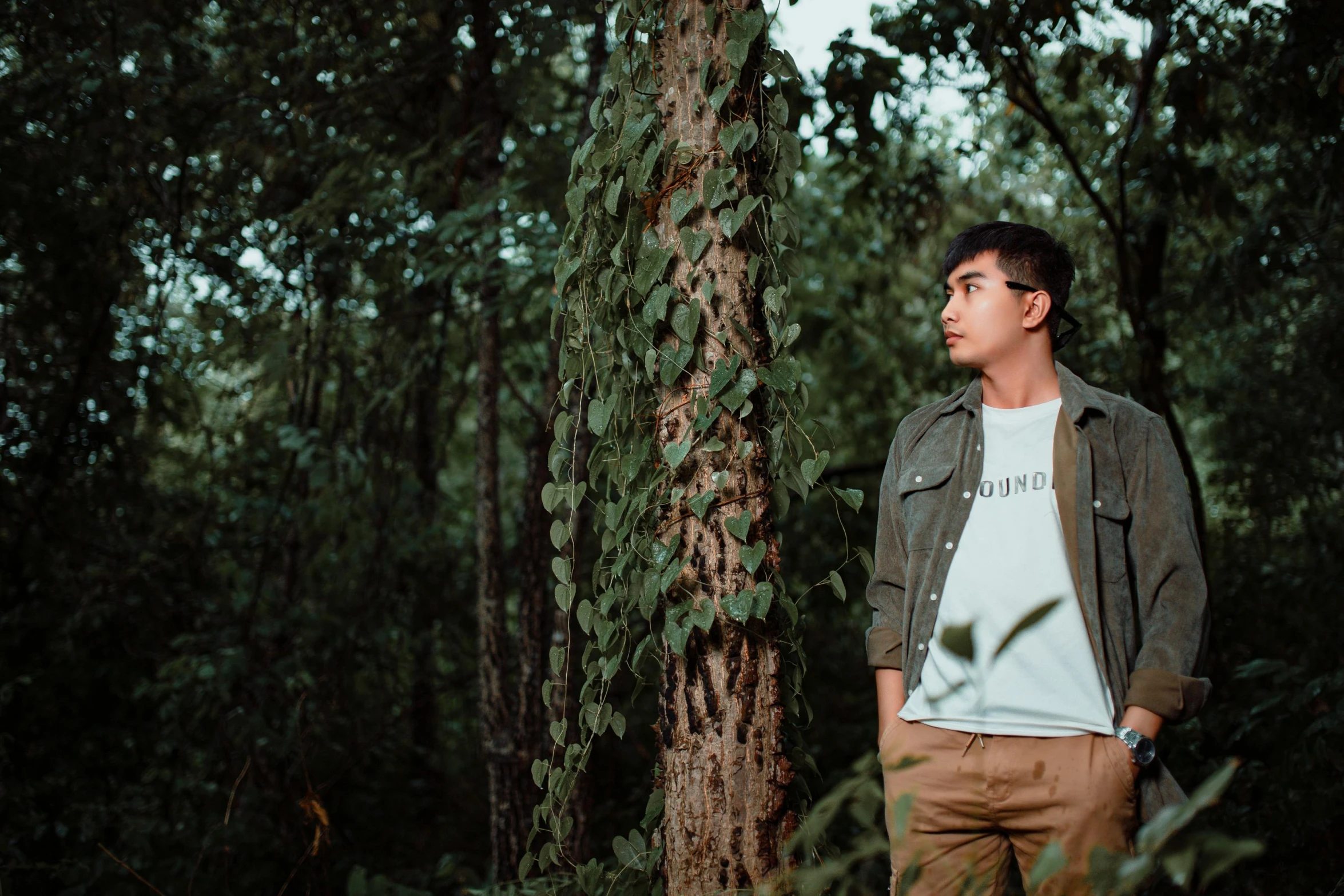 a man is standing next to a large tree