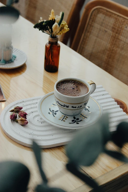 a tea cup and saucer with an assortment of small flowers