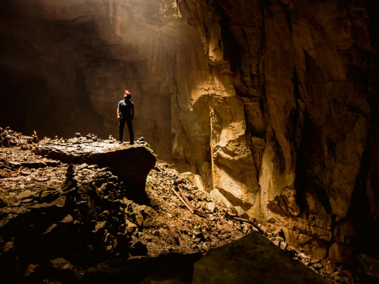 a man in the dark is standing at a rock