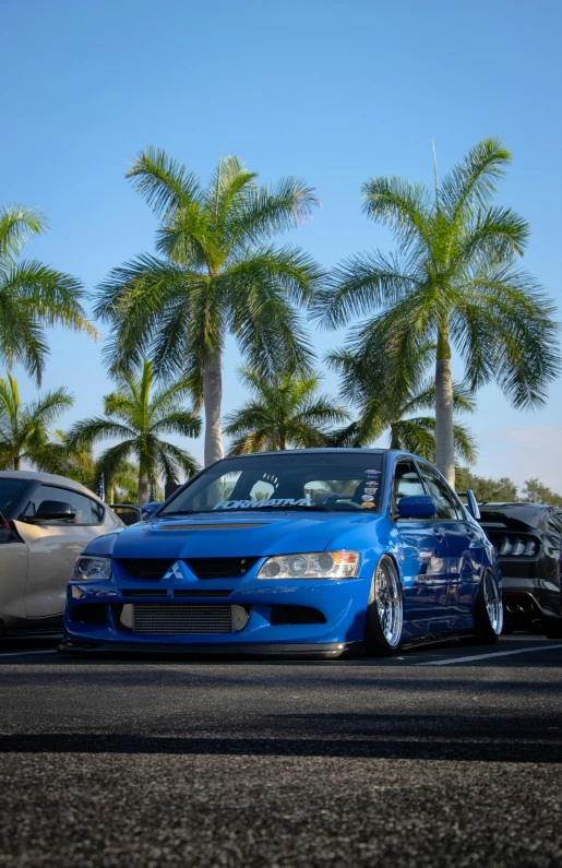 a blue car parked next to a white car