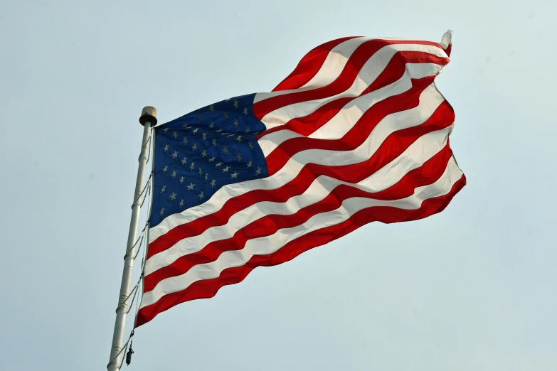 american flag waving in the wind on a flag pole