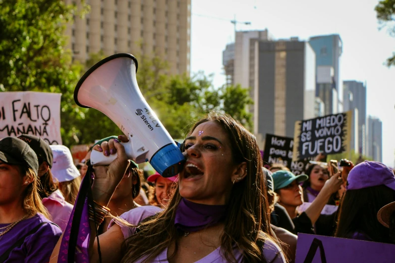 some women hold up signs, while one has a megaphone in her hand