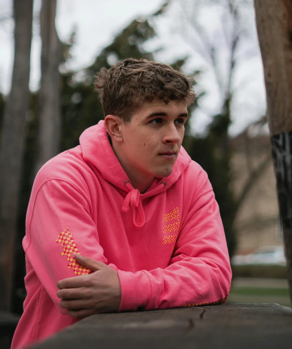 a man sitting on top of a bench next to a tree