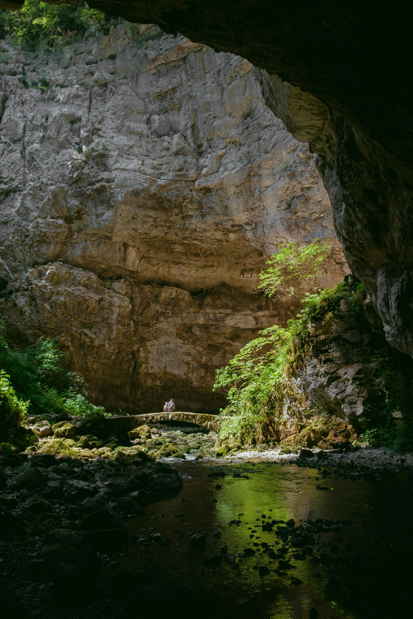 water flowing under an arch in a cave