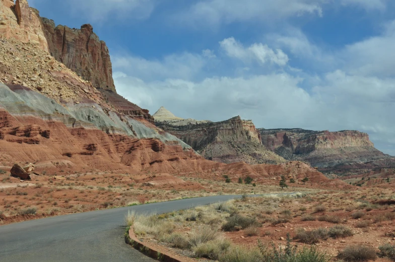 a road going through a canyon with mountains in the background