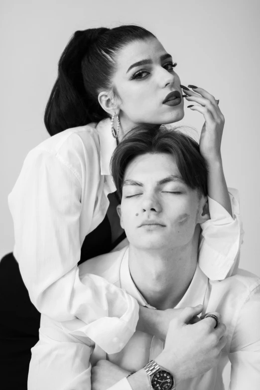 a young man sitting in front of a woman holding a watch