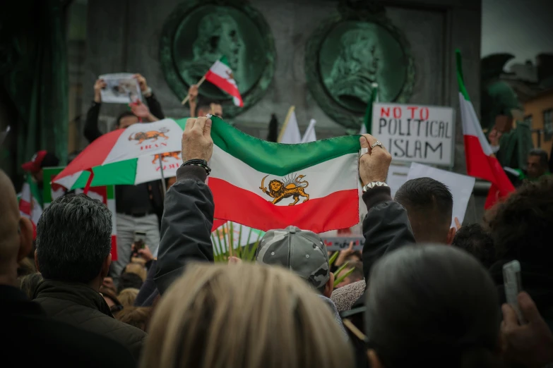a man holds up several flags for mexicans to protest