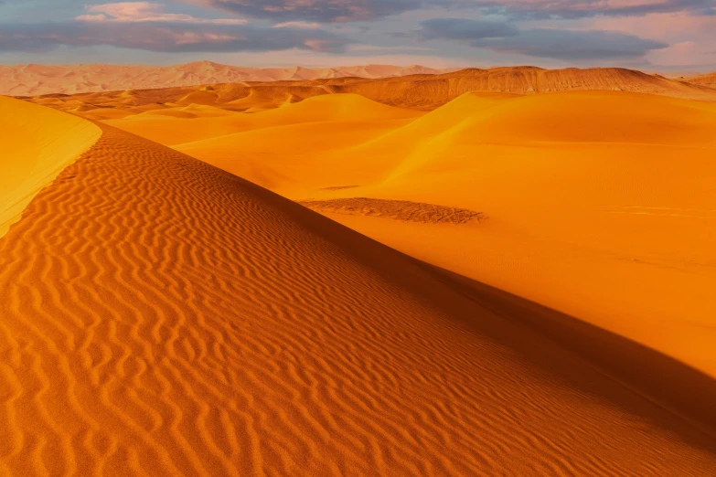 a desert like setting with sand dunes and mountains