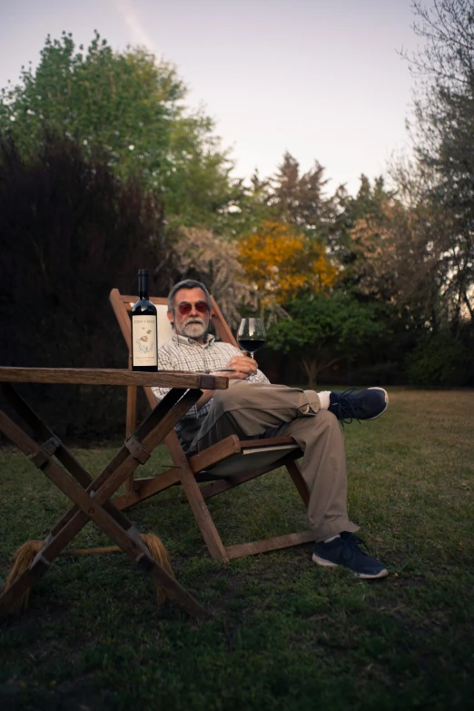 a man sitting in a chair holding a bottle and a sign