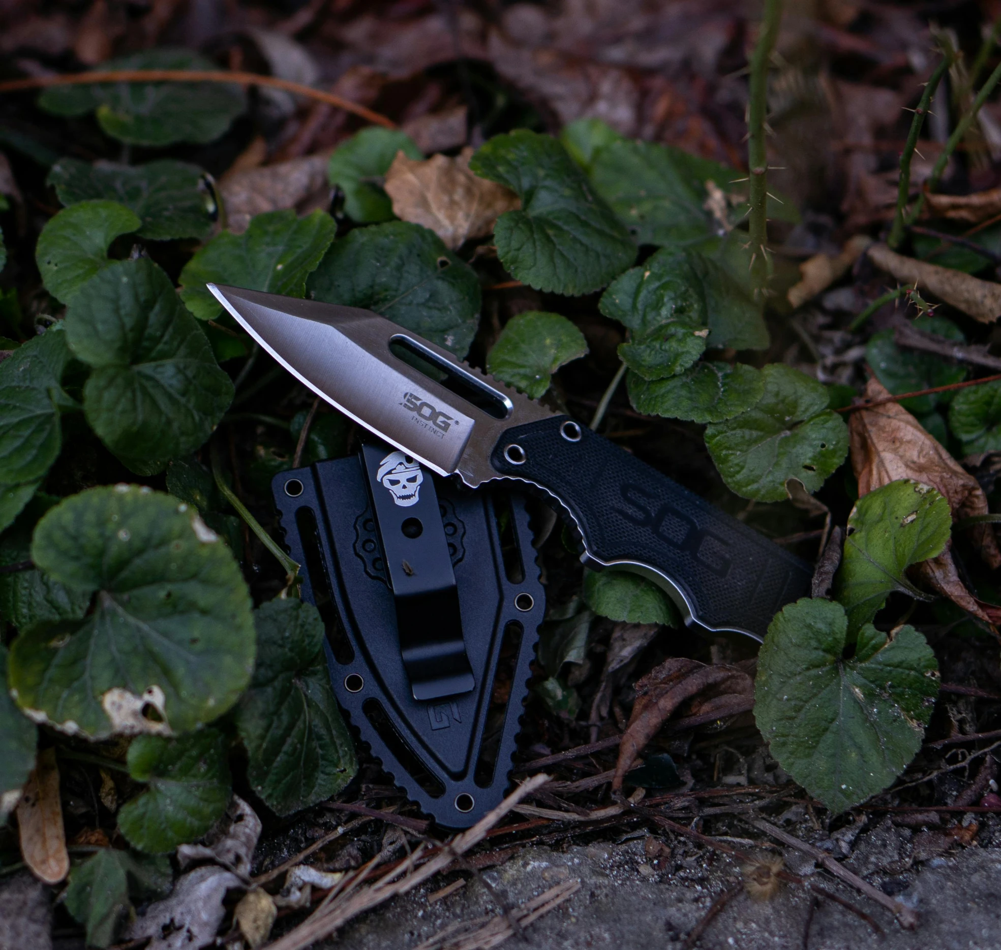 a knife and wallet that are laying down in the grass