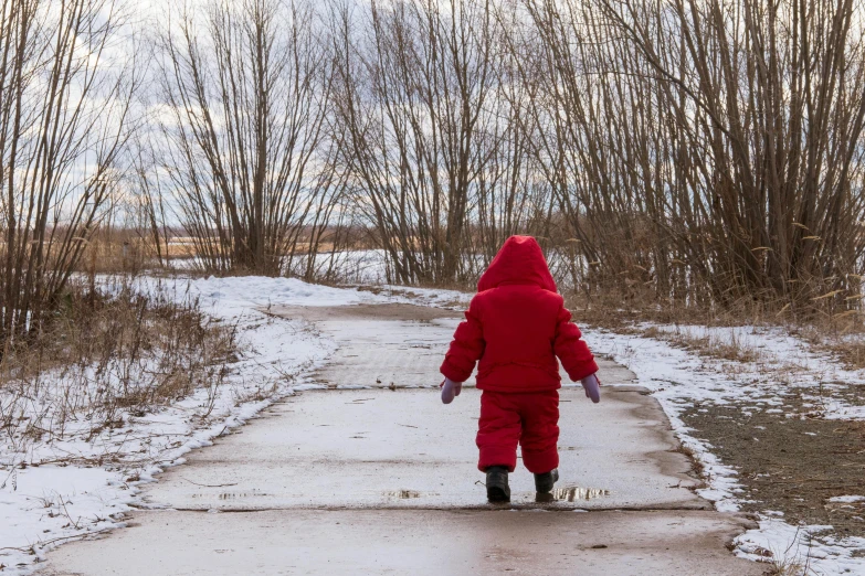 a person in a red outfit is walking on the sidewalk