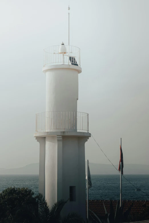 a tower next to the ocean with an american flag