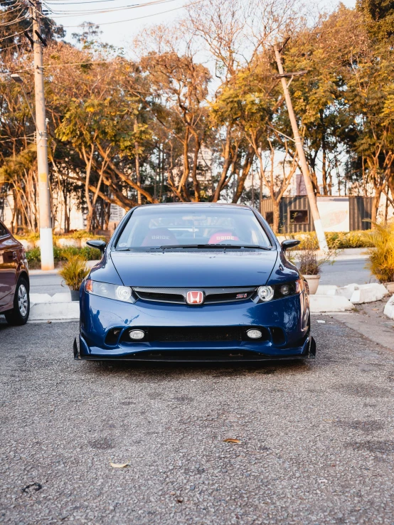 the blue car is parked in front of two other cars