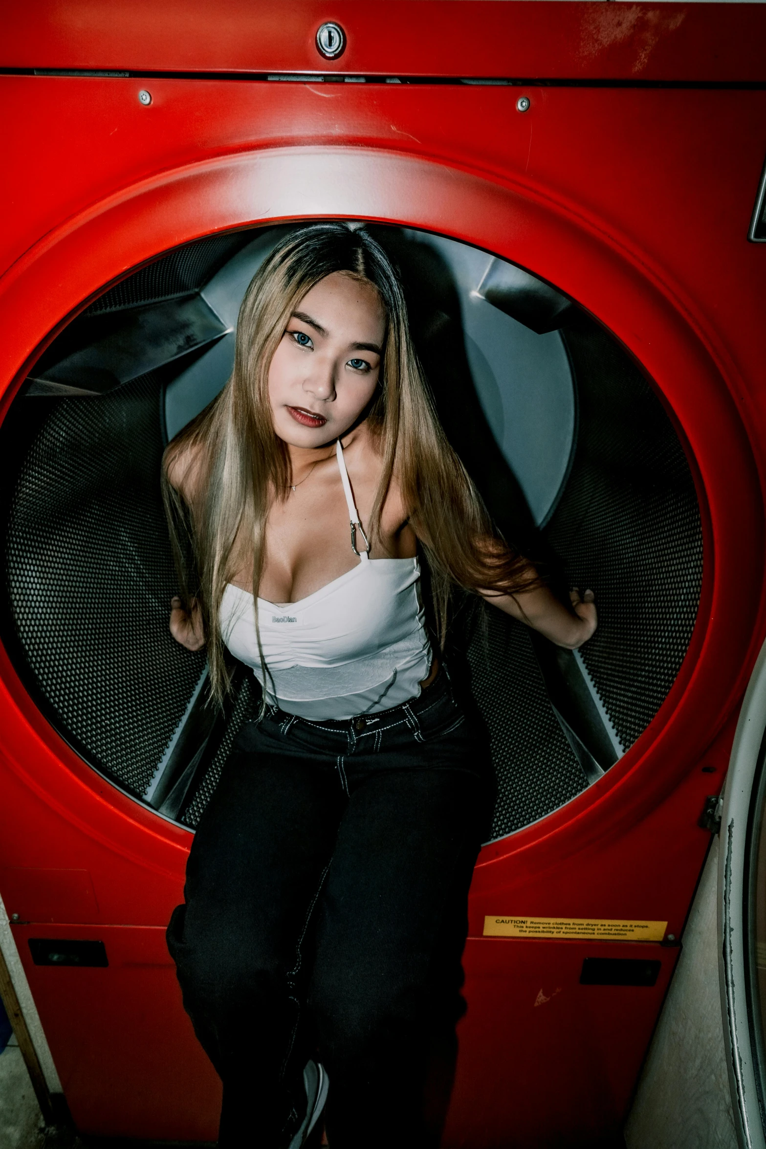 a woman standing in front of a dryer with her headphones on