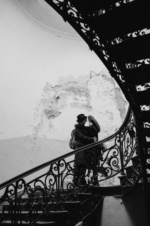 a man and woman standing on stairs under a dome