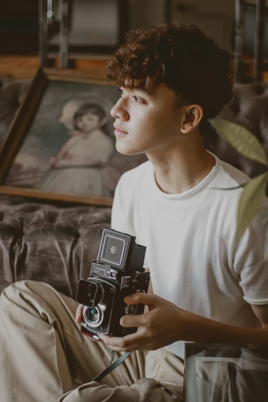 boy holding camera and posing for the camera