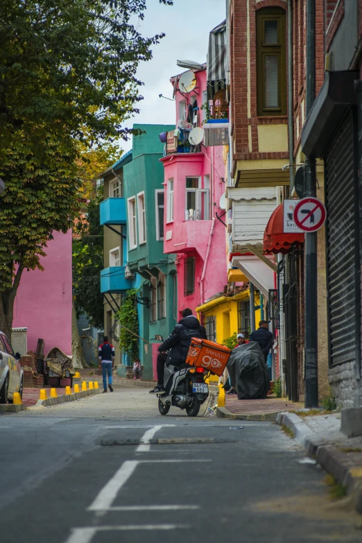 a man riding on the back of a motorcycle down a street