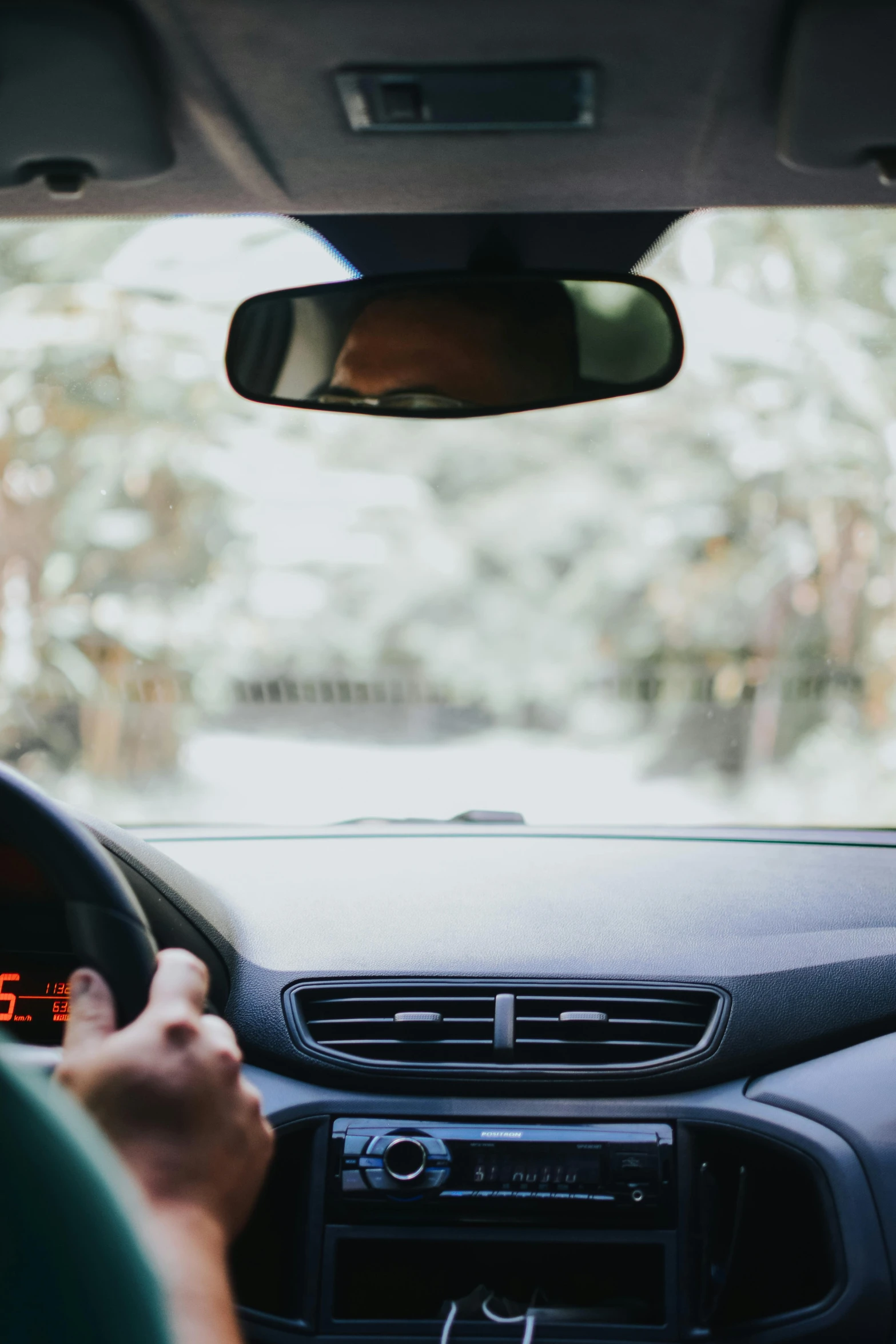 a man driving a car while holding his hand on the dashboard