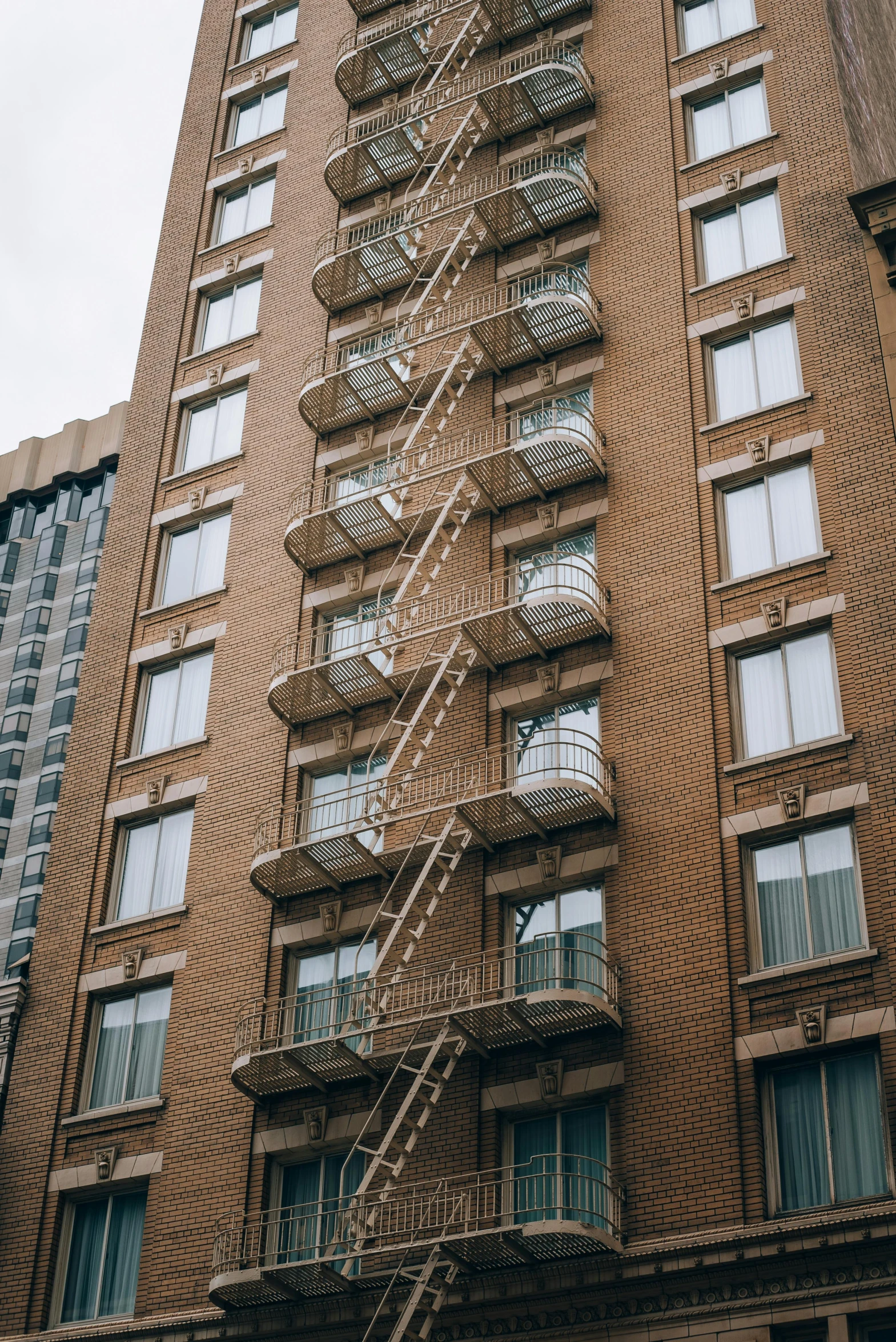 a tall brick building with metal stairs and a skylight