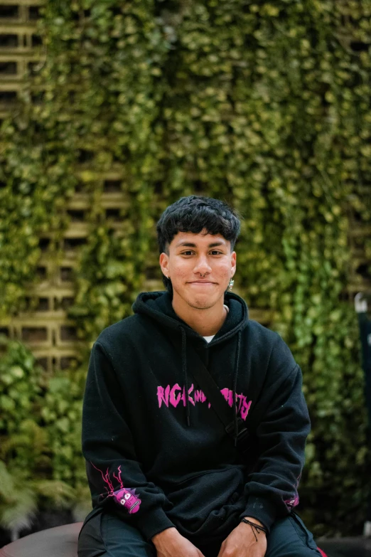 an image of a young man wearing a black sweatshirt and sweatpants