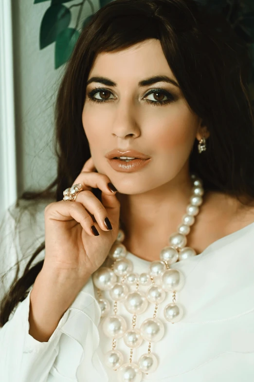 a woman with pearls on her neck and a necklace