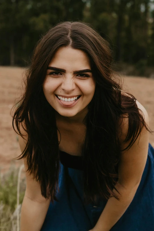 a smiling woman posing for a pograph outside