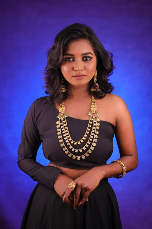 a woman in black outfit wearing an elaborate necklace