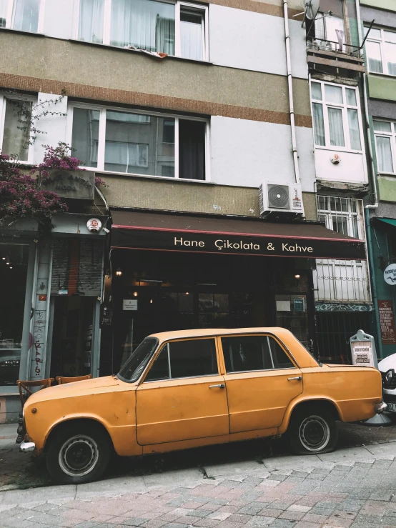 an old car is parked outside a shop