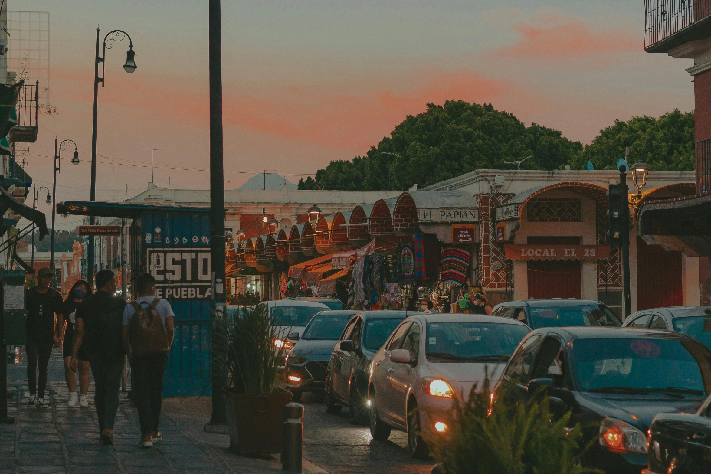 the street is filled with vehicles in front of people walking