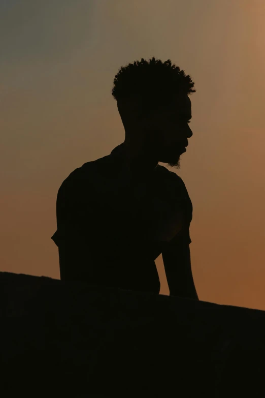 the silhouette of a man standing next to a motorcycle