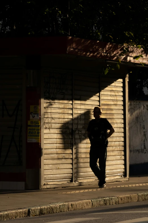 a person standing on the sidewalk with their shadow