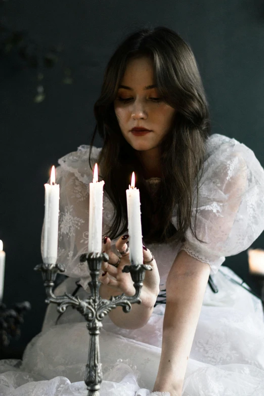 a woman lights candles while kneeling down