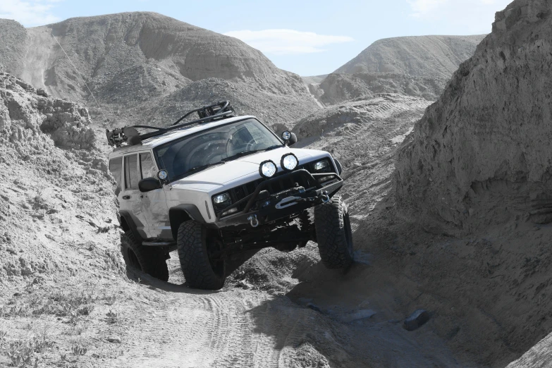 the four door vehicle is going through the rocky terrain