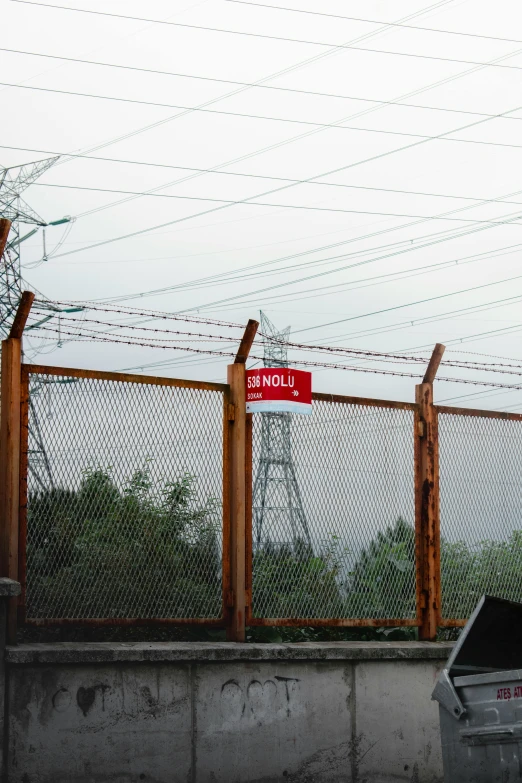 there are several red and white signs on a wire fence