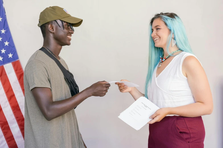 a girl standing beside a man in front of an american flag