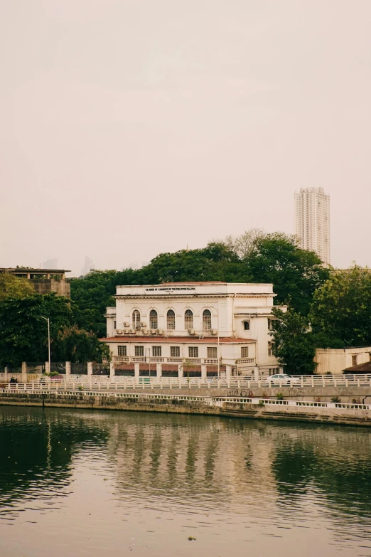 an older building sits on the bank of the river