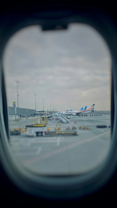 a window with an airplane parked at the airport