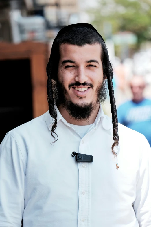 a smiling man with long hair and a goatee