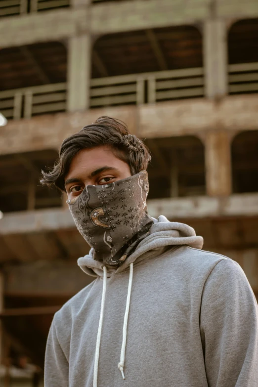 man wearing a mask in front of a building under construction