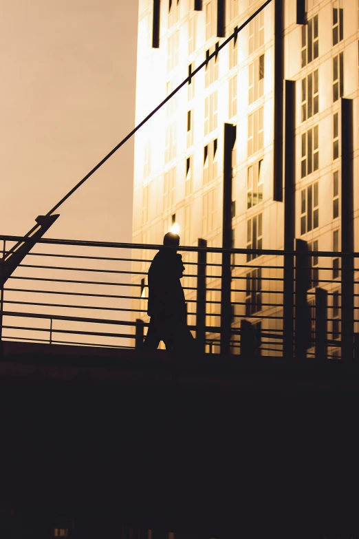 a person walking on a bridge near tall buildings