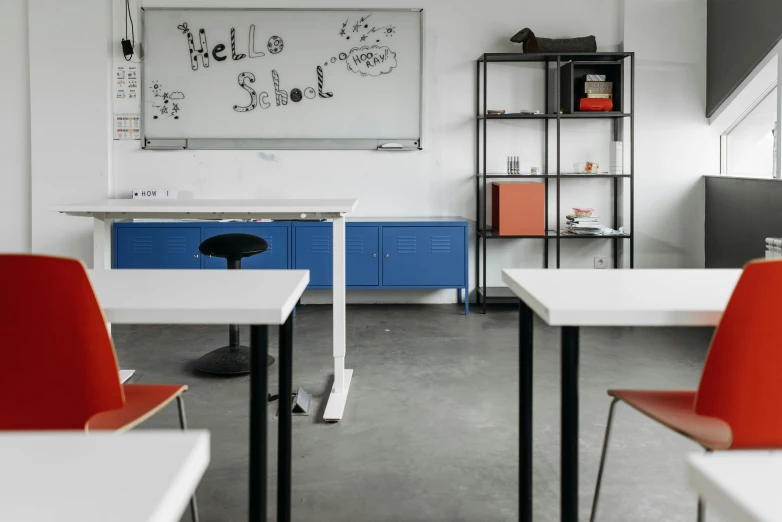 a classroom with a chalkboard and lots of tables