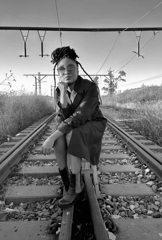 a woman is sitting on a railroad track