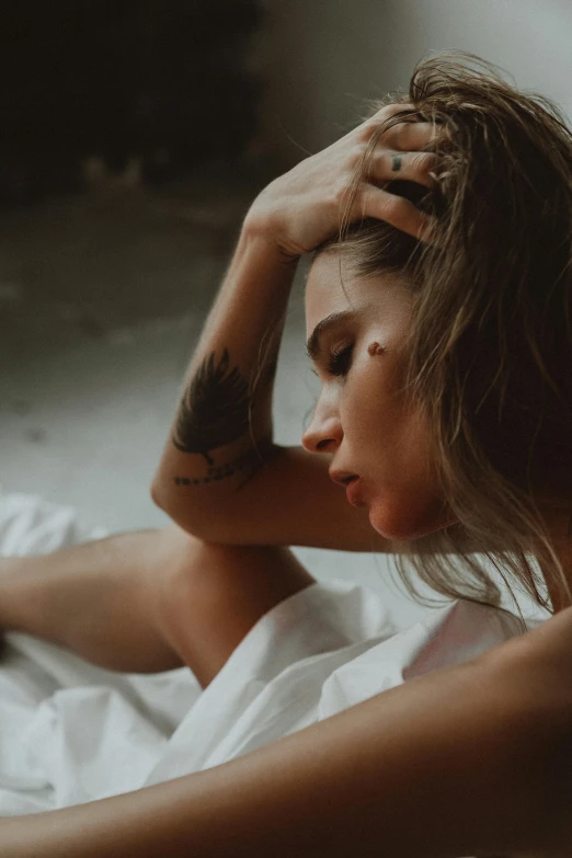 a woman wearing white is laying in bed