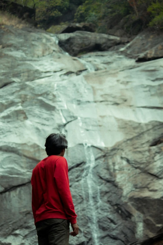 a man standing in front of a large waterfall