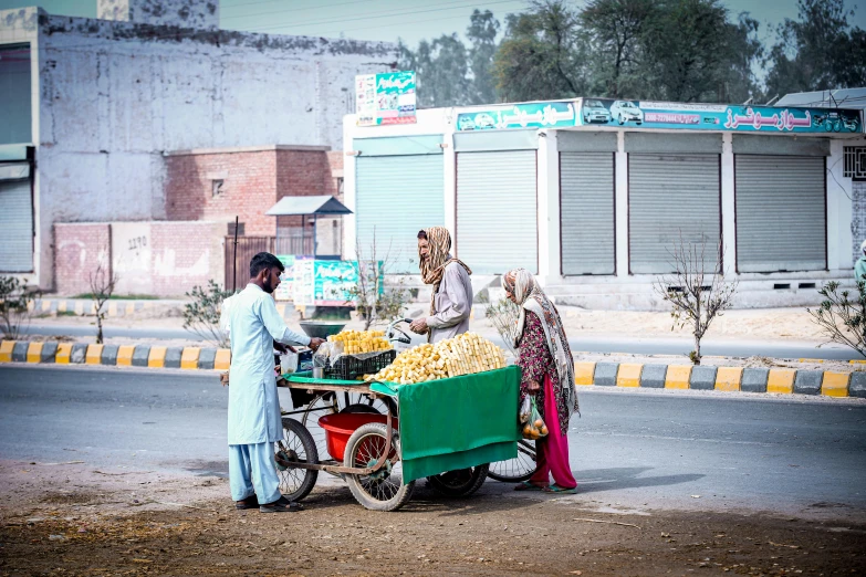 three people shopping on a small motorcycle with a green trailer